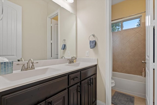 full bath with double vanity, a sink, shower / bath combination, and toilet