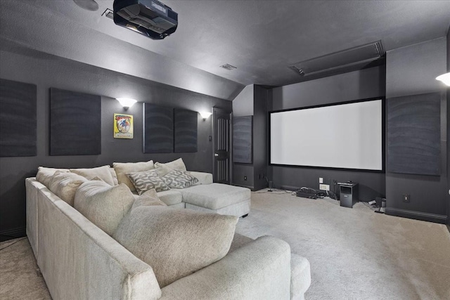 home theater room with visible vents, lofted ceiling, and carpet