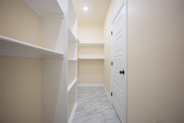spacious closet with marble finish floor