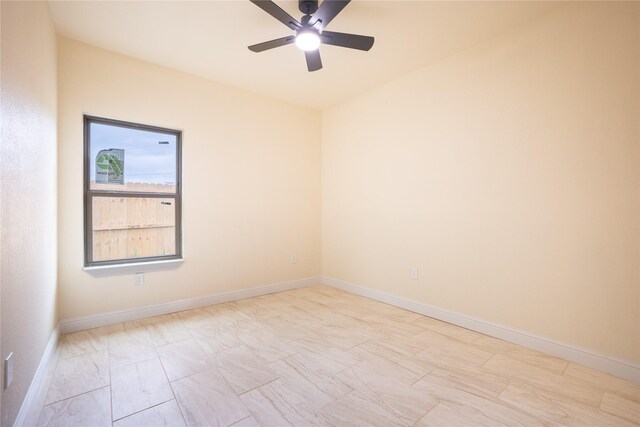 unfurnished room with ceiling fan and baseboards