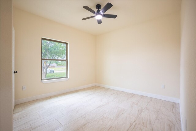 unfurnished room featuring ceiling fan and baseboards