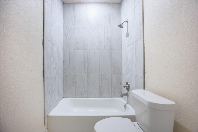 full bath featuring a textured wall, toilet, and shower / washtub combination
