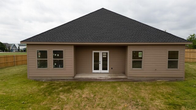 rear view of property with french doors, roof with shingles, fence, a yard, and a patio