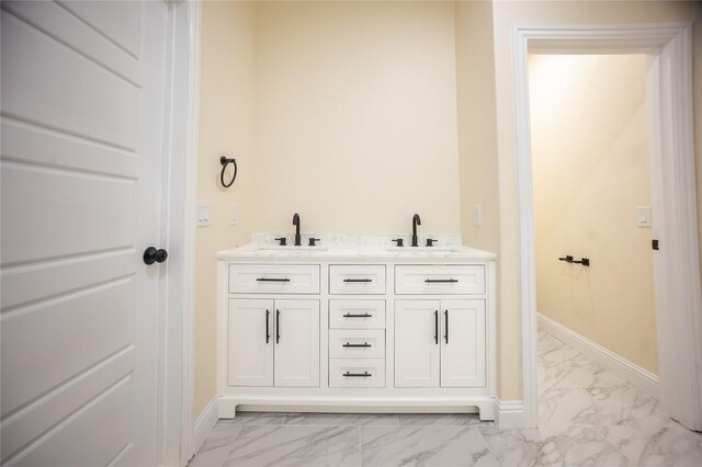 full bathroom featuring baseboards, a sink, and marble finish floor