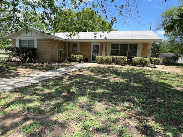 ranch-style house featuring brick siding and fence