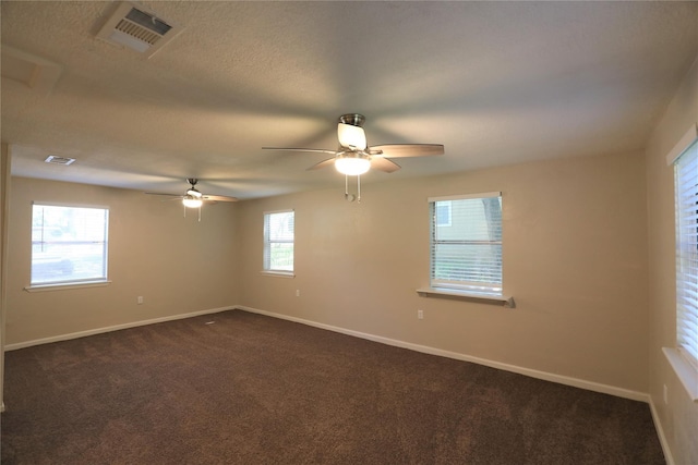 empty room featuring visible vents, baseboards, dark carpet, and ceiling fan