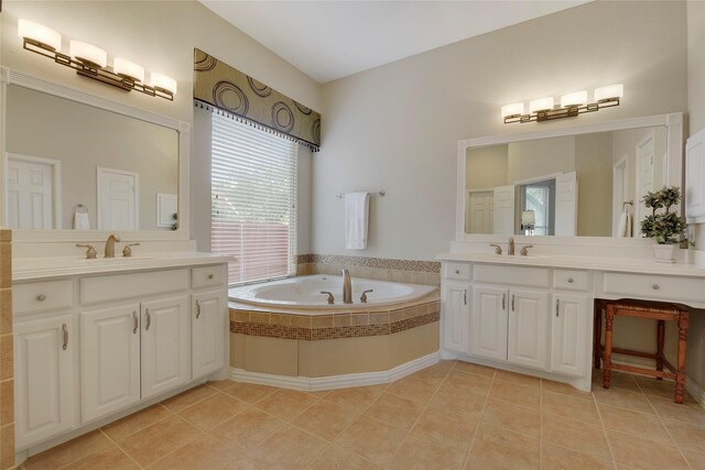bathroom with a sink, a bath, tile patterned floors, and two vanities