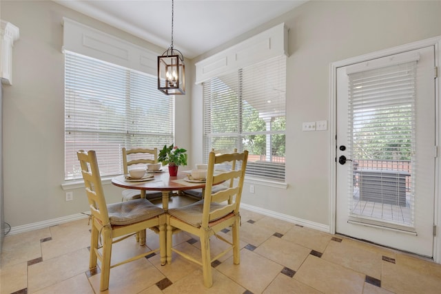 dining room featuring baseboards, light tile patterned floors, and a chandelier