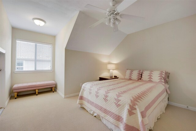 bedroom featuring baseboards, lofted ceiling, and carpet