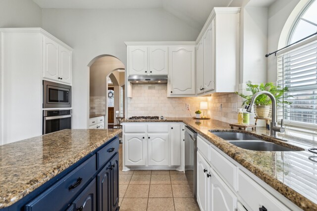 kitchen with a sink, appliances with stainless steel finishes, blue cabinets, and white cabinetry