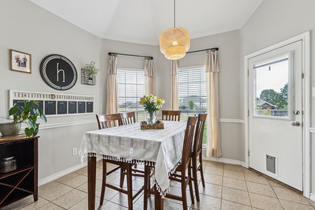 dining area with baseboards, visible vents, light tile patterned floors, and lofted ceiling