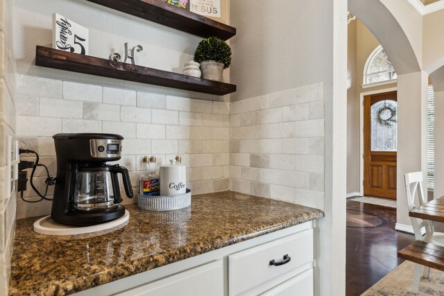 kitchen with open shelves, backsplash, dark stone countertops, and white cabinetry