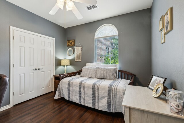 bedroom featuring a ceiling fan, visible vents, and wood finished floors