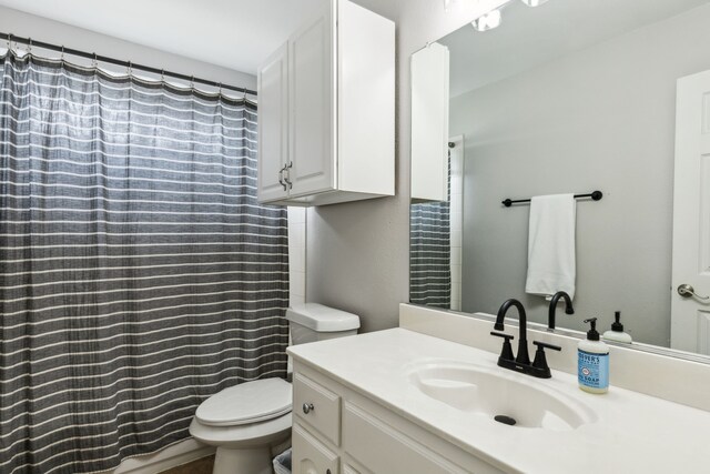 full bathroom with toilet, curtained shower, and vanity