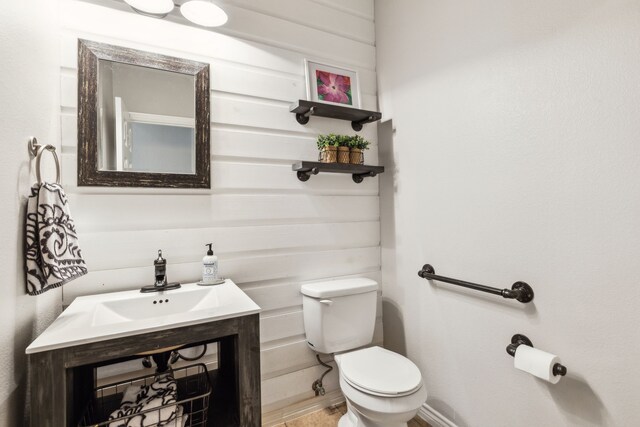half bathroom featuring vanity and toilet