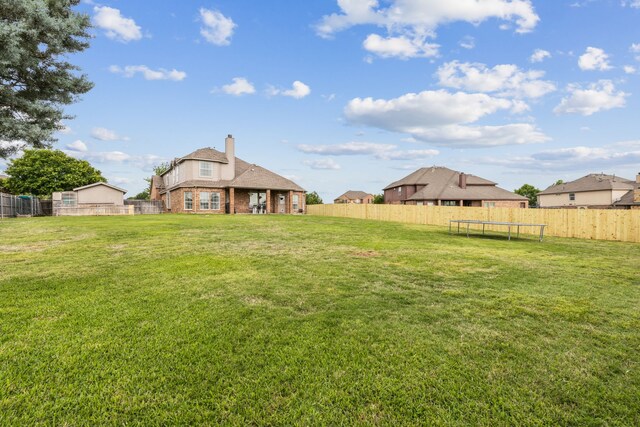 view of yard with a fenced backyard and a trampoline
