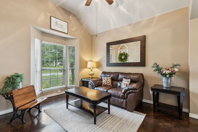 living room featuring baseboards, ceiling fan, vaulted ceiling, and finished concrete floors