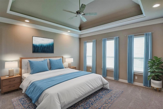 carpeted bedroom with ceiling fan, crown molding, baseboards, a tray ceiling, and recessed lighting