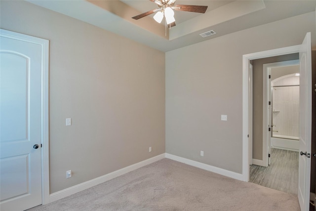 unfurnished bedroom with baseboards, carpet floors, and a raised ceiling
