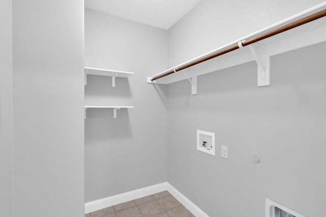 washroom with laundry area, hookup for a washing machine, baseboards, electric dryer hookup, and light tile patterned floors