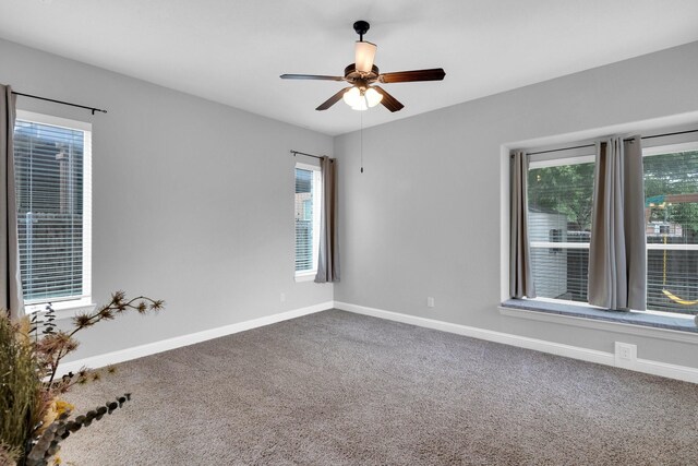 unfurnished room with carpet floors, baseboards, and a ceiling fan