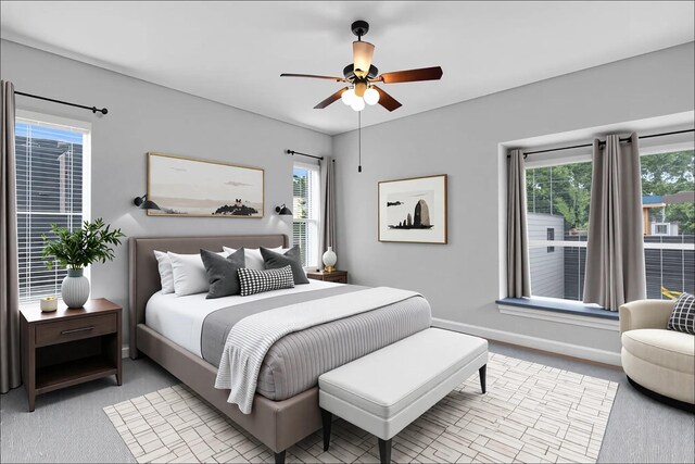 bedroom featuring a ceiling fan, baseboards, multiple windows, and light carpet