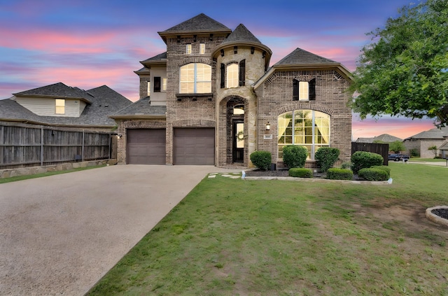 french country style house with fence, concrete driveway, a garage, and brick siding