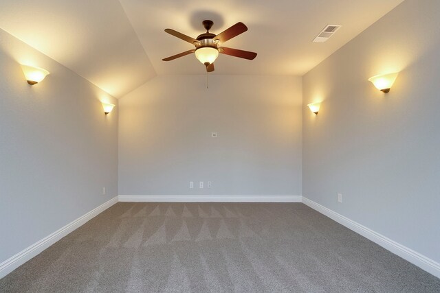 carpeted empty room featuring ceiling fan, visible vents, baseboards, and vaulted ceiling