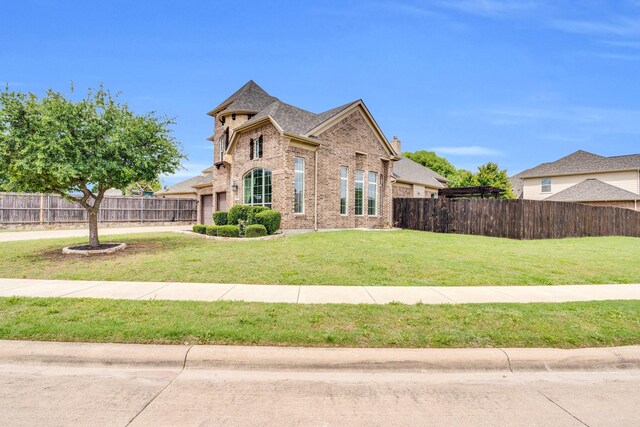 view of front facade with brick siding, fence, driveway, and a front lawn