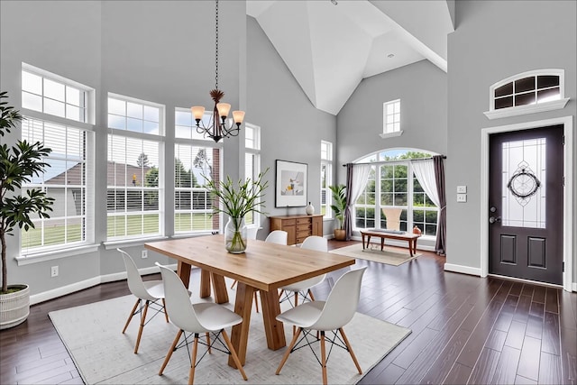 dining space with high vaulted ceiling, baseboards, a chandelier, and dark wood-type flooring