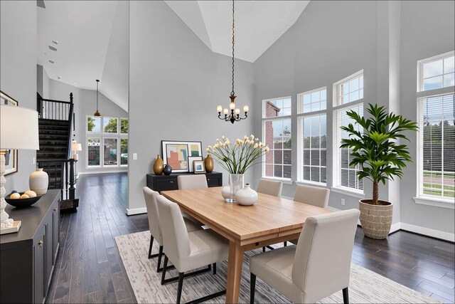 dining room featuring dark wood-type flooring, a wealth of natural light, high vaulted ceiling, and an inviting chandelier