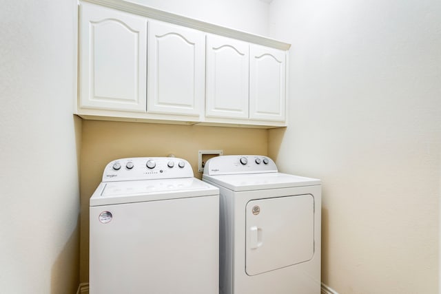 washroom featuring cabinet space and washer and clothes dryer