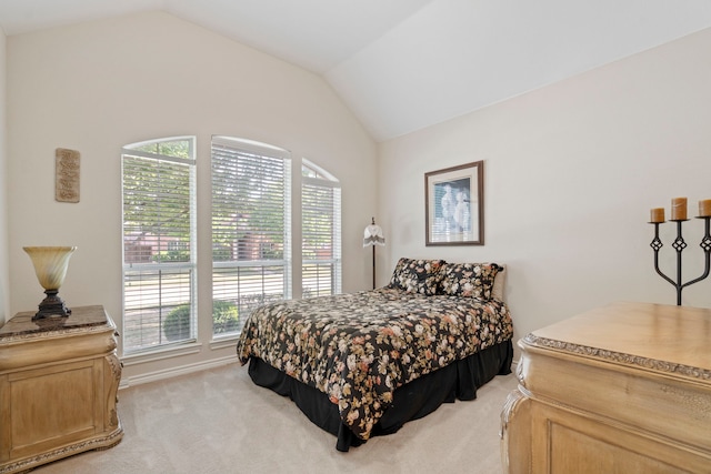 bedroom featuring light colored carpet and lofted ceiling