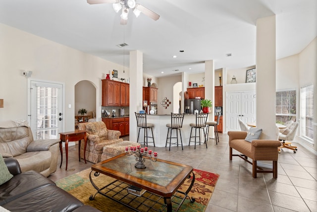 living room featuring arched walkways, a ceiling fan, recessed lighting, and light tile patterned floors