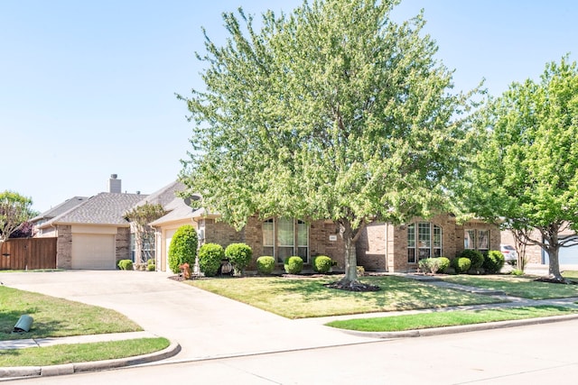 obstructed view of property with concrete driveway, brick siding, a front yard, and a garage