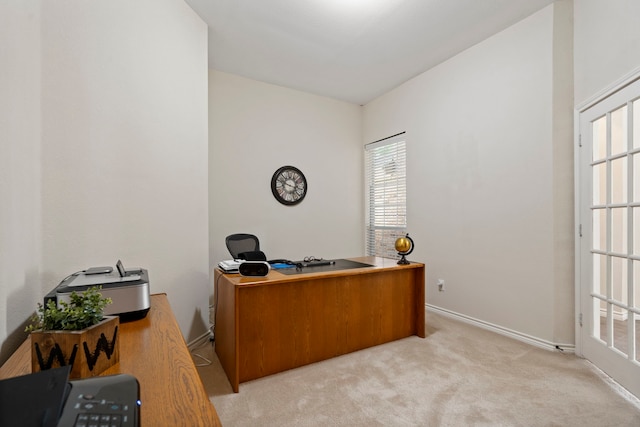 office featuring baseboards and light carpet
