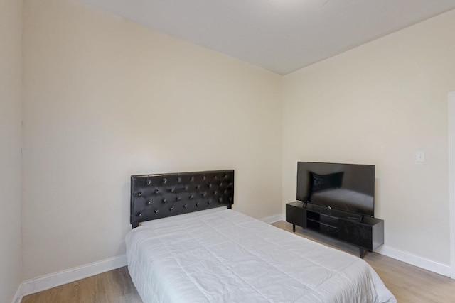 bedroom featuring baseboards and wood finished floors