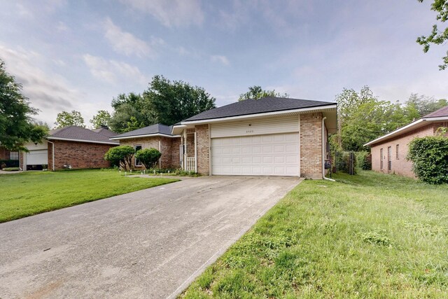 ranch-style house with brick siding, driveway, a front yard, and a garage