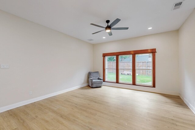 unfurnished room with baseboards, ceiling fan, wood finished floors, and visible vents