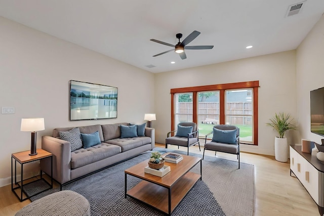 living room featuring visible vents, a ceiling fan, light wood finished floors, and baseboards