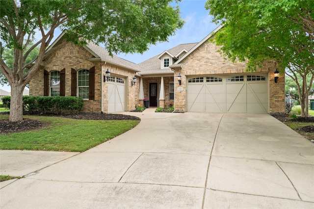 view of front of property featuring a front lawn, roof with shingles, brick siding, concrete driveway, and an attached garage