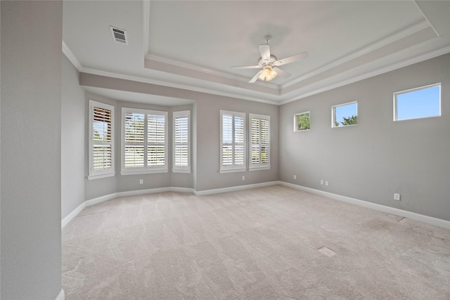 unfurnished room featuring plenty of natural light, ornamental molding, and a tray ceiling