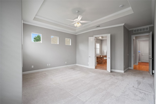 unfurnished bedroom with a raised ceiling, baseboards, light carpet, and visible vents