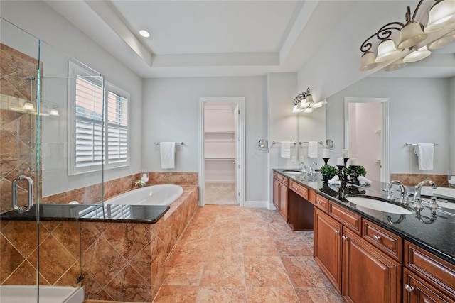 bathroom featuring double vanity, a shower stall, a sink, and a garden tub