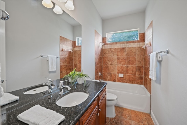 full bath featuring shower / bathtub combination, toilet, stone finish floor, and vanity