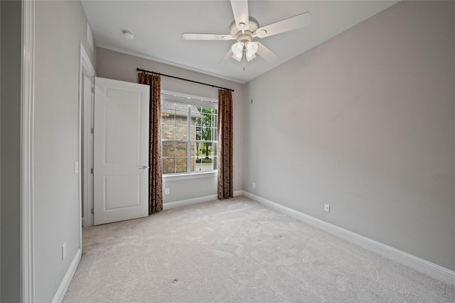 carpeted spare room with baseboards and ceiling fan