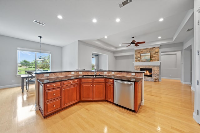 kitchen featuring visible vents, a sink, a raised ceiling, and dishwasher