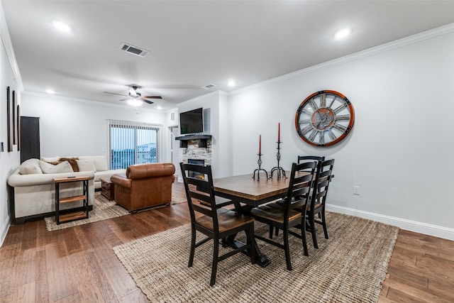 dining space featuring visible vents, a ceiling fan, baseboards, and dark wood-style floors