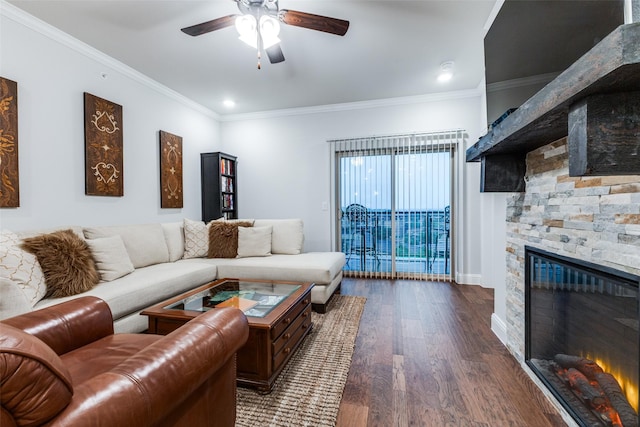 living area with ornamental molding, wood finished floors, a fireplace, baseboards, and ceiling fan