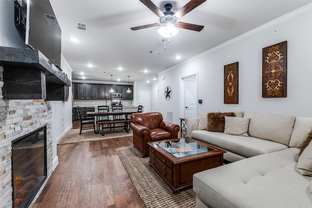 living room with ceiling fan, visible vents, crown molding, dark wood finished floors, and recessed lighting